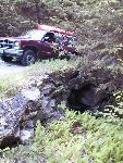 A stone retaining wall leading up to an elevated stone bridge